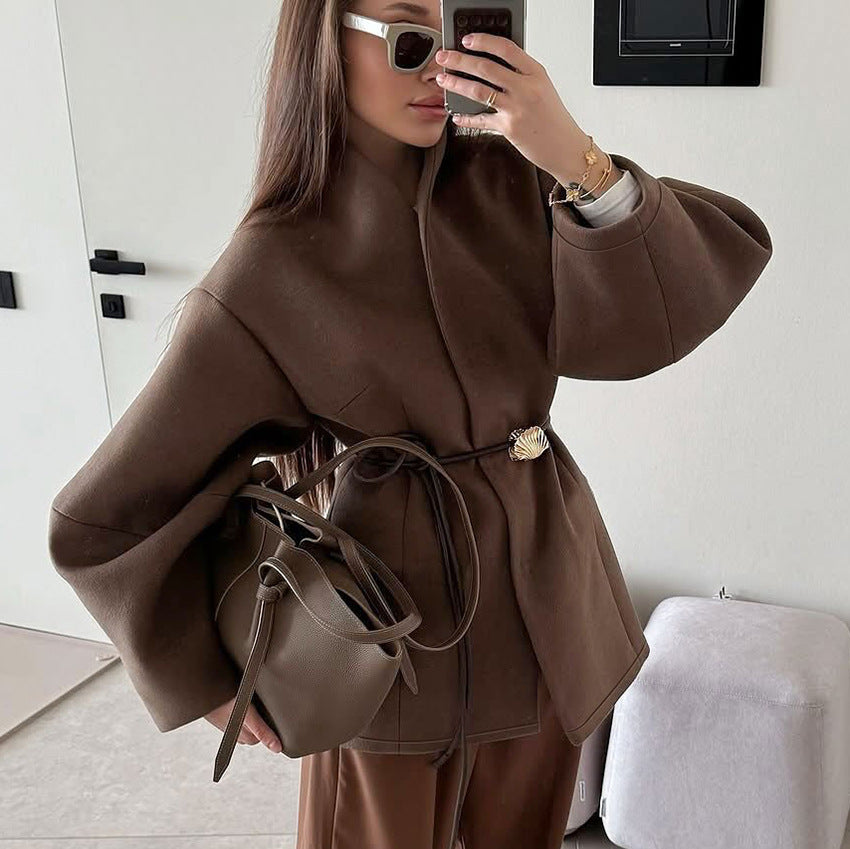 This high-end brown cinched-waist woolen coat for women in autumn and winter exudes a stylish and elegant design